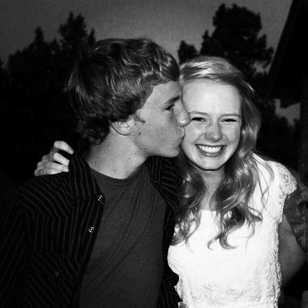 brother kissing sister's cheek at a wedding